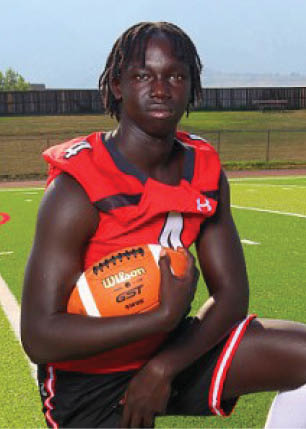 A young man wearing a white and black jersey with the number 14 on it. Description generated by AI