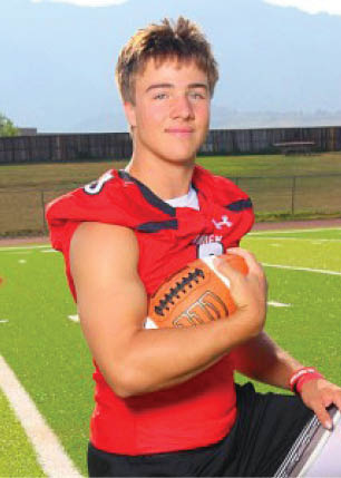 A young man wearing a white and black jersey with the number 14 on it. Description generated by AI