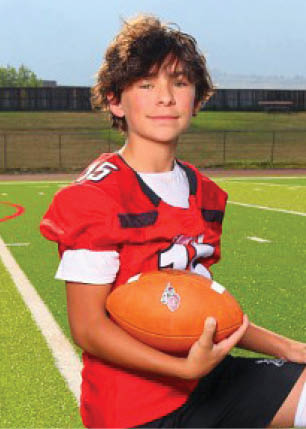 A young man wearing a white and black jersey with the number 14 on it. Description generated by AI