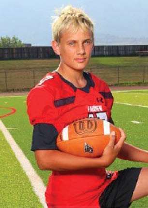 A young man wearing a white and black jersey with the number 14 on it. Description generated by AI