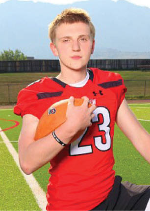 A young man wearing a white and black jersey with the number 14 on it. Description generated by AI