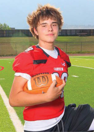 A young man wearing a white and black jersey with the number 14 on it. Description generated by AI
