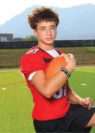 A young man wearing a white and black jersey with the number 14 on it. Description generated by AI