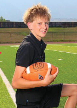 A young man wearing a white and black jersey with the number 14 on it. Description generated by AI