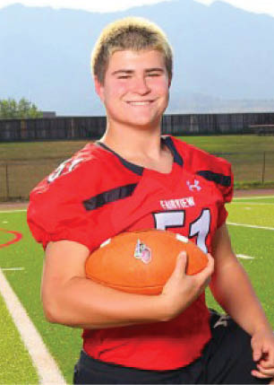 A young man wearing a white and black jersey with the number 14 on it. Description generated by AI