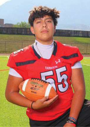A young man wearing a white and black jersey with the number 14 on it. Description generated by AI