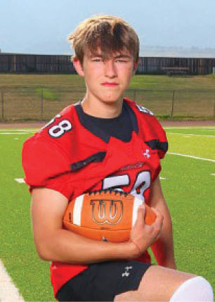 A young man wearing a white and black jersey with the number 14 on it. Description generated by AI