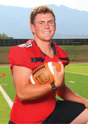 A young man wearing a white and black jersey with the number 14 on it. Description generated by AI