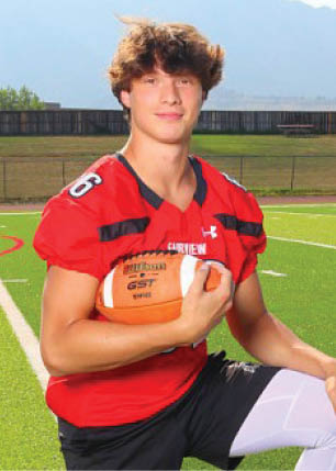 A young man wearing a white and black jersey with the number 14 on it. Description generated by AI