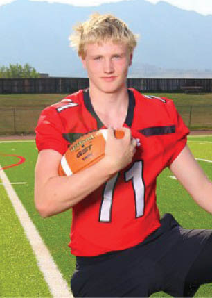 A young man wearing a white and black jersey with the number 14 on it. Description generated by AI