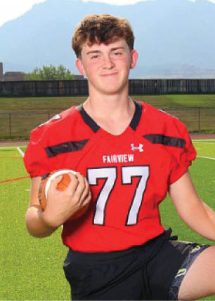 A young man wearing a white and black jersey with the number 14 on it. Description generated by AI