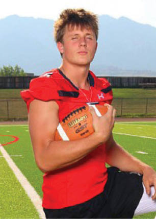 A young man wearing a white and black jersey with the number 14 on it. Description generated by AI