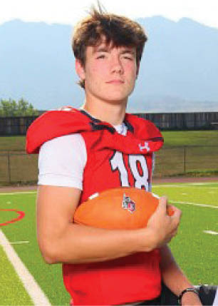 A young man wearing a white and black jersey with the number 14 on it. Description generated by AI