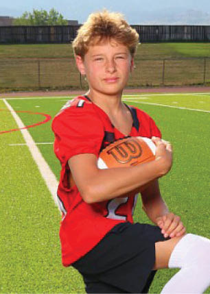 A young man wearing a white and black jersey with the number 14 on it. Description generated by AI