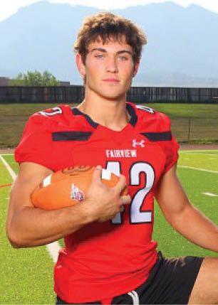 A young man wearing a white and black jersey with the number 14 on it. Description generated by AI
