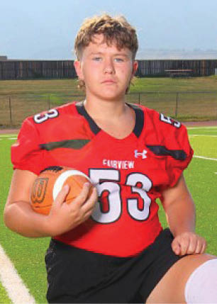 A young man wearing a white and black jersey with the number 14 on it. Description generated by AI