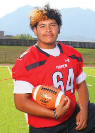 A young man wearing a white and black jersey with the number 14 on it. Description generated by AI