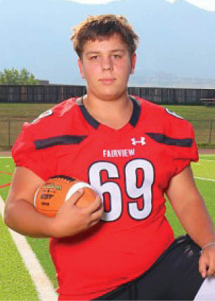 A young man wearing a white and black jersey with the number 14 on it. Description generated by AI