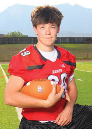 A young man wearing a white and black jersey with the number 14 on it. Description generated by AI