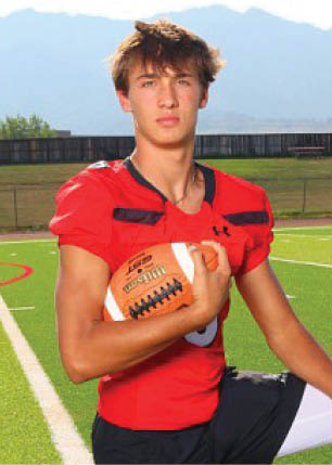 A young man wearing a white and black jersey with the number 14 on it. Description generated by AI