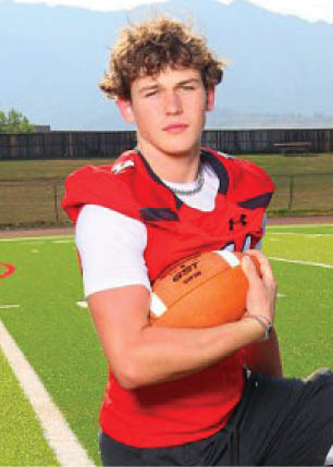 A young man wearing a white and black jersey with the number 14 on it. Description generated by AI