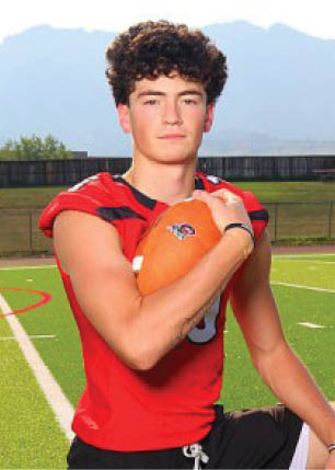 A young man wearing a white and black jersey with the number 14 on it. Description generated by AI