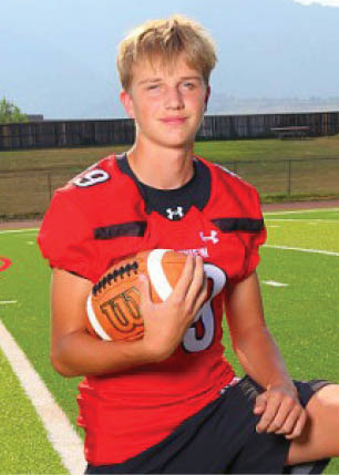 A young man wearing a white and black jersey with the number 14 on it. Description generated by AI
