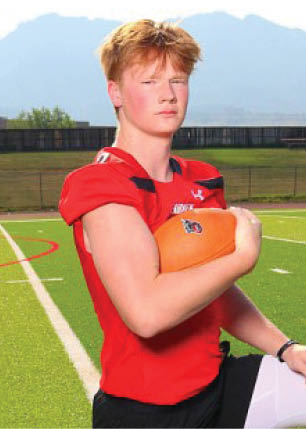 A young man wearing a white and black jersey with the number 14 on it. Description generated by AI
