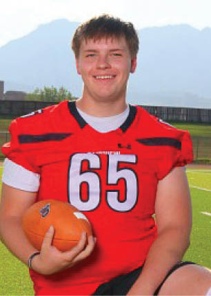 A young man wearing a white and black jersey with the number 14 on it. Description generated by AI