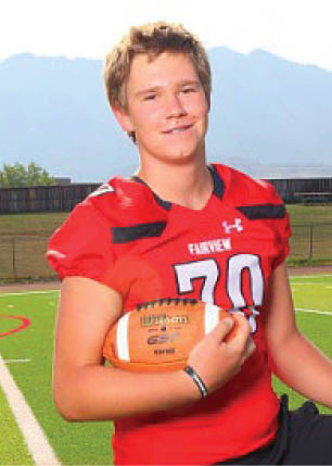 A young man wearing a white and black jersey with the number 14 on it. Description generated by AI