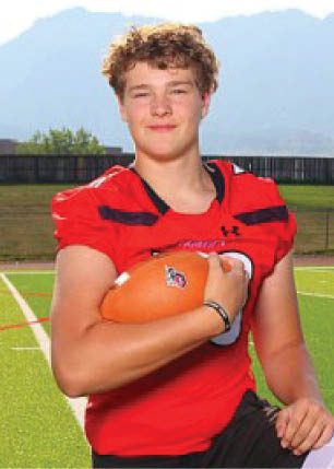 A young man wearing a white and black jersey with the number 14 on it. Description generated by AI