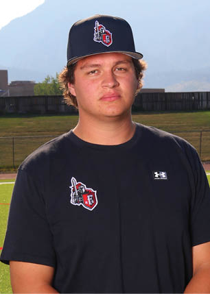 A young man wearing a white and black jersey with the number 14 on it. Description generated by AI