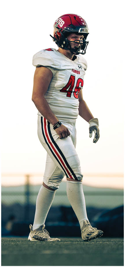 A football player wearing a blue and white uniform. Description generated by AI