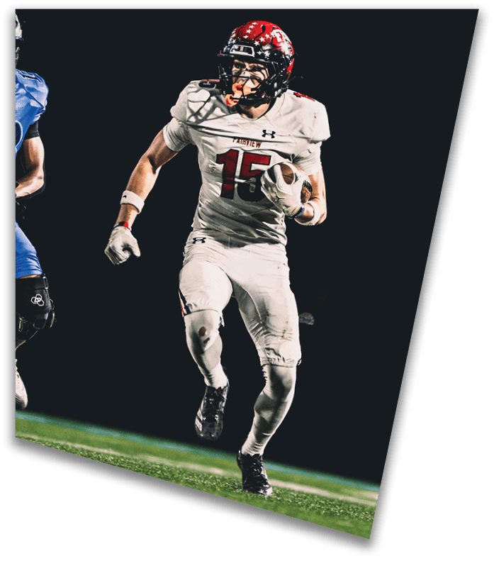 A person wearing a dark football uniform and helmet with “American Canyon" on the jersey is kneeling on one knee on a field at night. Description generated by AI