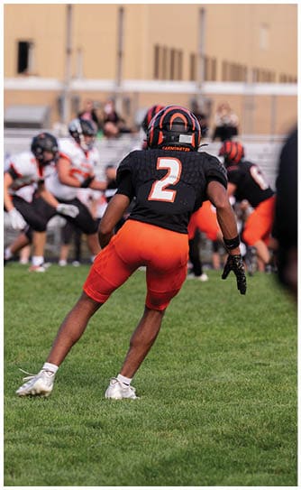 A football player catching a ball. Description generated by AI