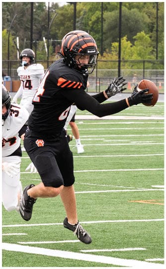 A football player catching a ball. Description generated by AI