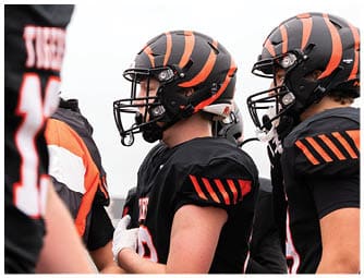 A group of football players on a field. Description generated by AI