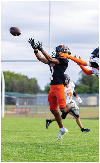 A football player catching a ball. Description generated by AI
