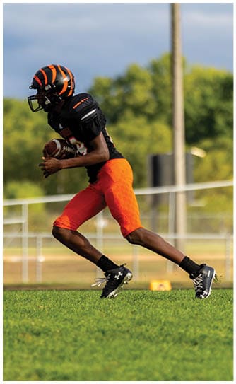 A football player catching a ball. Description generated by AI