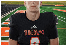 A young man wearing a white jersey with the number 10 on it. Description generated by AI
