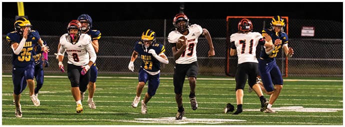A football player wearing a blue and white uniform. Description generated by AI