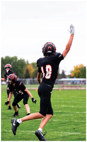 A football player catching a ball. Description generated by AI
