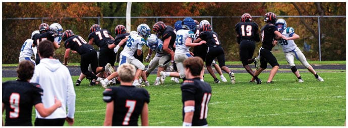 A football player wearing a blue and white uniform. Description generated by AI