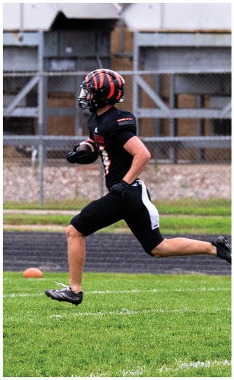 A football player catching a ball. Description generated by AI