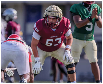 Several people in football uniforms are positioned on a field preparing for a play during a game. Description generated by AI