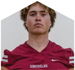 Person with tousled hair wearing a maroon sports jersey with the word “SEMINOLES" on the front. Description generated by AI