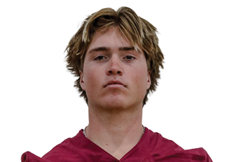 Person with medium-length hair wearing a maroon football jersey with the number 5 and the word Seminoles on the front stands facing forward with hands behind their back. Description generated by AI
