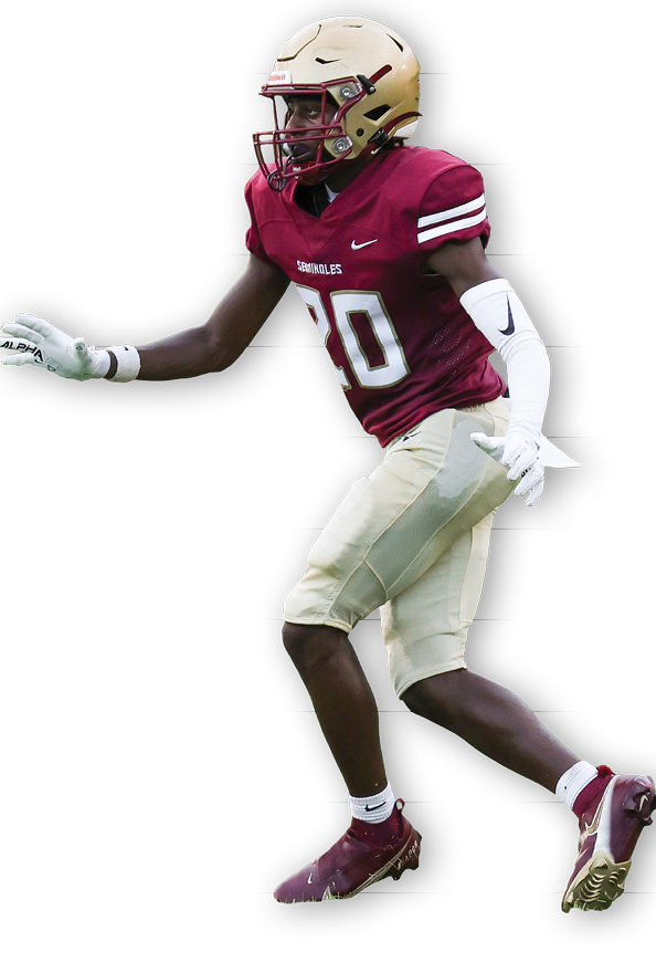 A person wearing a maroon football uniform with the number 20 and a gold helmet is in an athletic stance, appearing ready to catch or intercept a ball. Description generated by AI