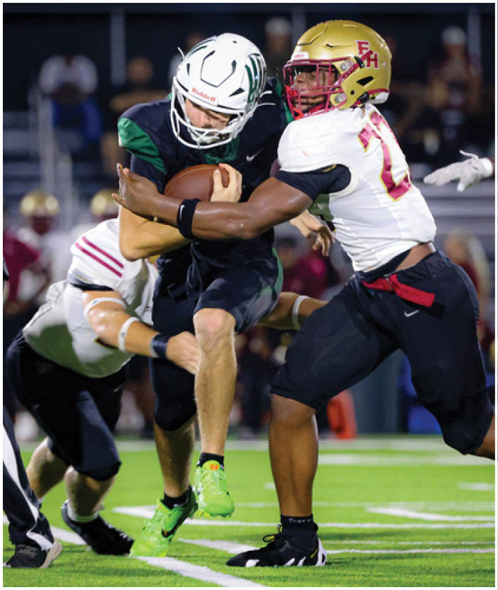Two opposing American football players in helmets and uniforms are lined up facing each other, preparing for the next play on the field. Description generated by AI
