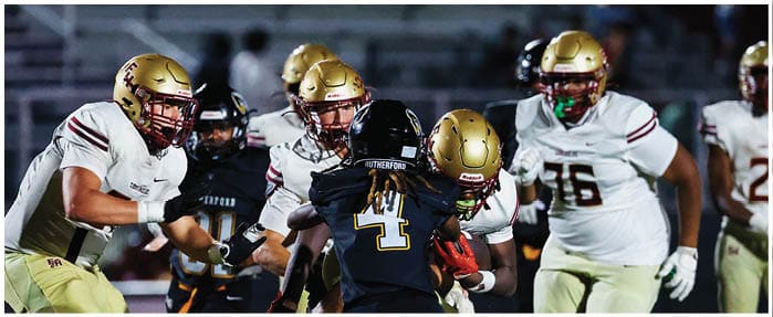 A football game is taking place with players on the field. Description generated by AI